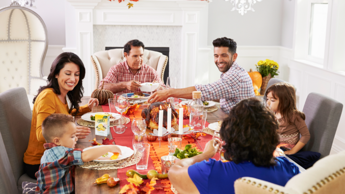 A family sharing a Thanksgiving meal with several vegetarian sides.