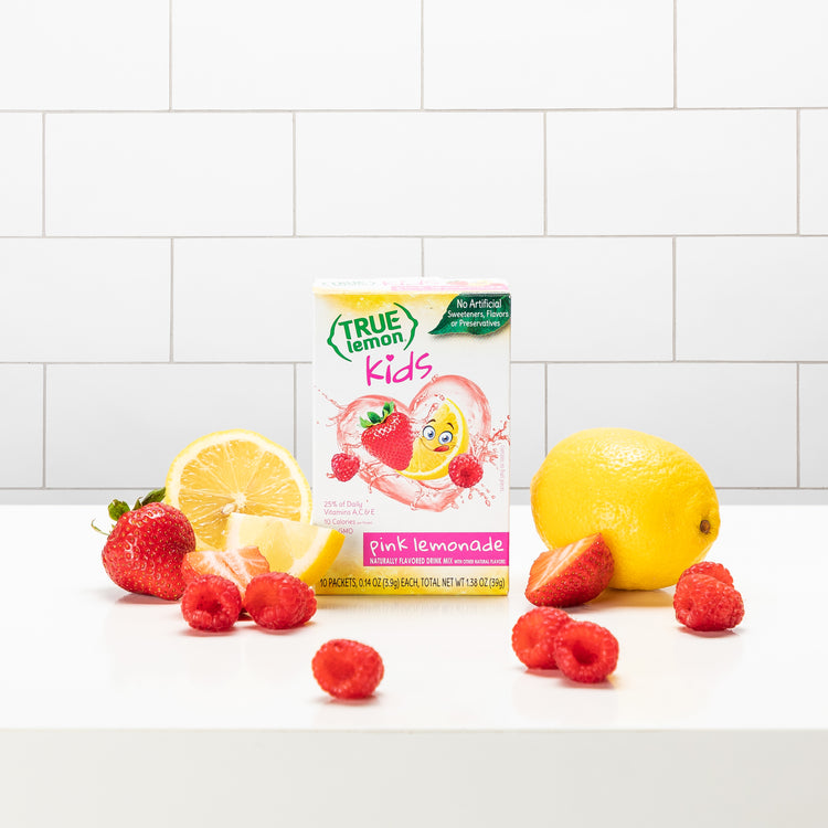 A box of True Lemon Kids Pink Lemonade with slices of lemon, strawberries, and raspberries around it.