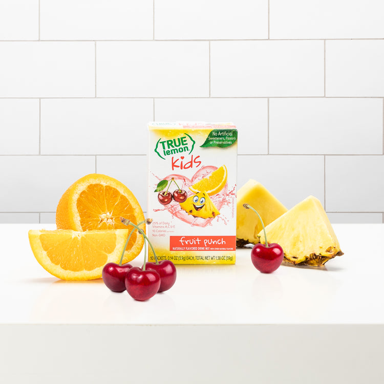 A box of True Lemon Kids Fruit Punch on a counter with slices of orange, pineapple, and cherries around it.